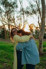Happy young woman smiles while hugging friend © Cavan