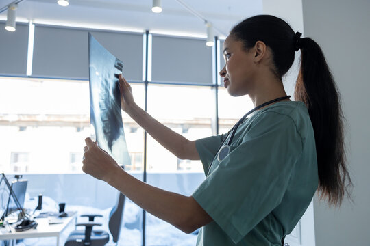 Long-haired asian female doctor with xray results in hands