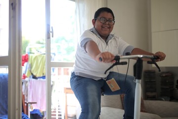 Happy boy with glasses riding cyclette at home © Cavan