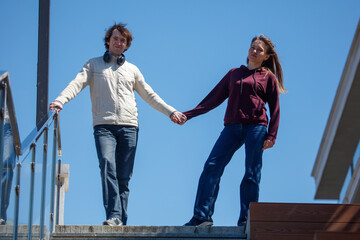 Obraz premium Couple walks hand in hand up outdoor stairs