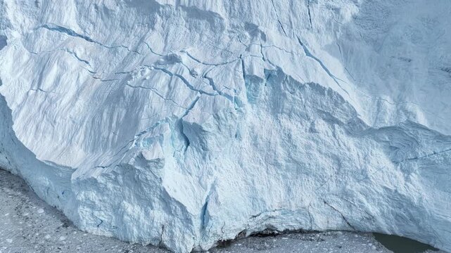 Vast cracking glacier face meets icy water