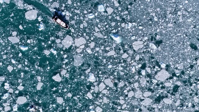 Top down view of boat sailing through icy waters