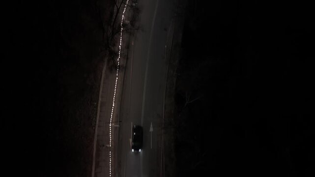 Lights along the road at night. A view of a winding road at night with lights marking the path. The scene captures the dark surroundings and the bright lights guiding drivers.