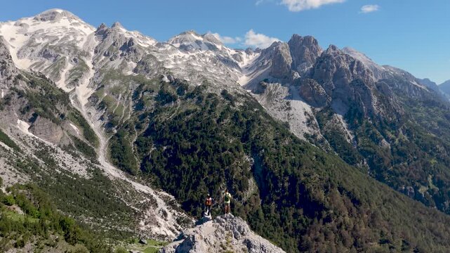 Albania showcases the magnificent Valbona Pass with panoramic views of towering peaks. A couple walking in the Albanian Alps near Theth