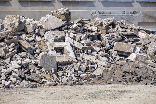 A large pile of concrete rubble and construction debris lies at a demolition site. This scene illustrates urban renewal processes and the environmental impact of building renovation projects.