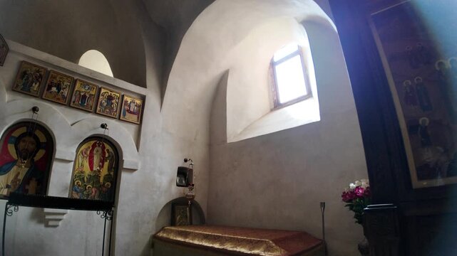 Vardzia, Georgia, May 1, 2025: Detailed iconostasis inside a rock-hewn monastery church, featuring religious icons and fresco elements of Georgian Orthodox tradition