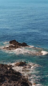 Mediterranean sea on the cretan coastline on a sunny day, drone vertical video
