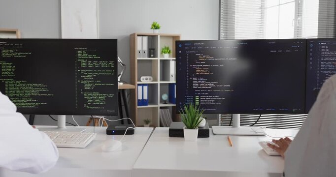 Programmers teamwork coding highfive success collaboration. Two developers raise hands at computer desks in a bright office by dual screens with code. Teamwork fuels productive coding success.