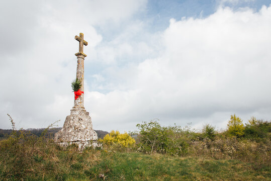 Calvaire avec un ruban rouge et du buis pour les rameaux de P&acirc;ques. Symbole chr&eacute;tien dans la campagne. Passion du Christ