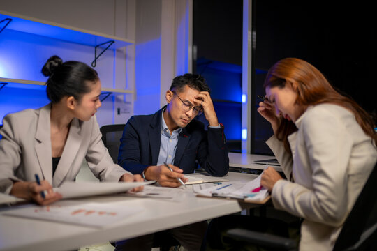 Business team experiencing stress during late night meeting
