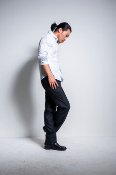 Asian man wearing shirt and trousers poses for photos