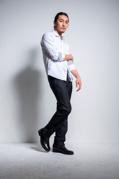 Asian man wearing shirt and trousers poses for photos
