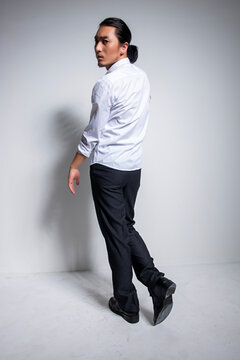 Asian man wearing shirt and trousers poses for photos
