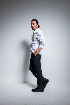 Asian man wearing shirt and trousers poses for photos