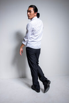Asian man wearing shirt and trousers poses for photos