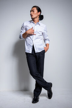 Asian man wearing shirt and trousers poses for photos