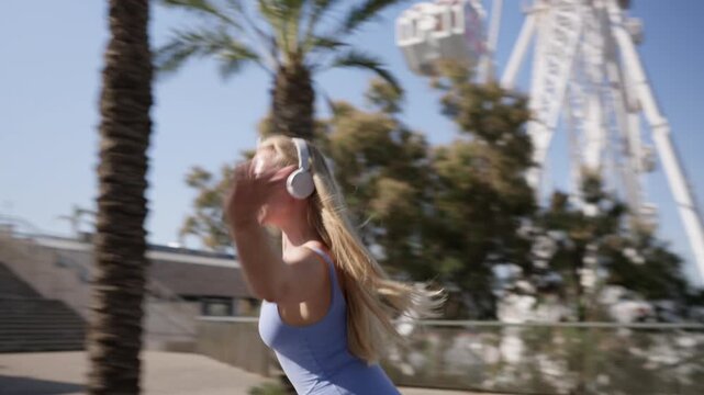 Blonde woman rollerblading and listening to music outdoors