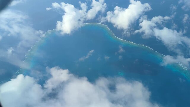 Flying high above Fijian coral reef and turquoise water ocean in small propeller airplane at outer islands of Fiji, South Pacific