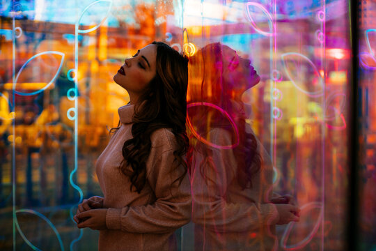 Urban fashion portrait with colorful glass reflection and neon light