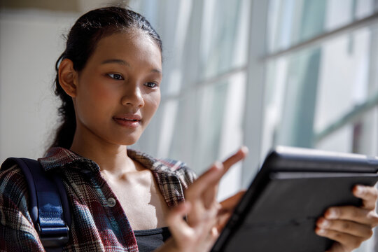 Curious student using tablet PC in university