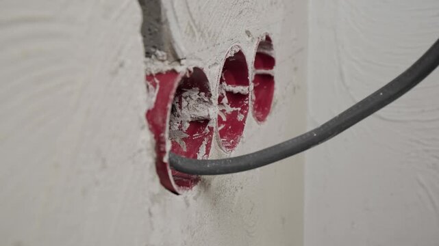 Camera moving closer to new electrical wiring with junction boxes installed in concrete base. Electrical installation during rough construction stage.