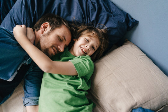 Father and son cuddling at home