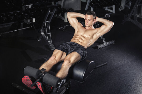 Physical athlete exercising with glute ham developer
