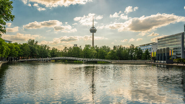 Germany, North Rhine-Westphalia, Cologne, MediaPark lake at dusk with Colonius tower in background