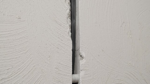 Close up of electrical wiring and junction boxes in concrete base as camera moves closer. Preparation of electrical system during home renovation work