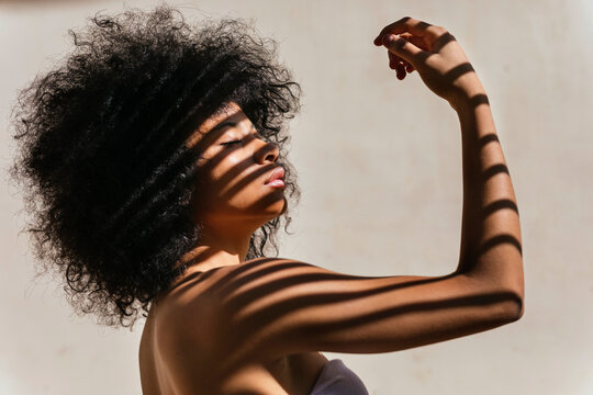 Portrait of young woman with shadow on her body