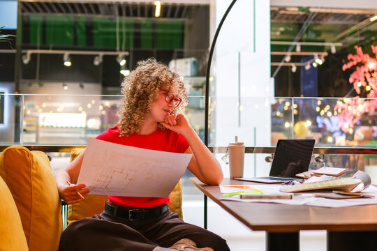 Architect analyzing blueprint at modern coworking space