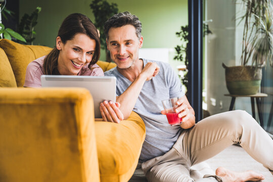 Couple using digital tablet while sitting at home