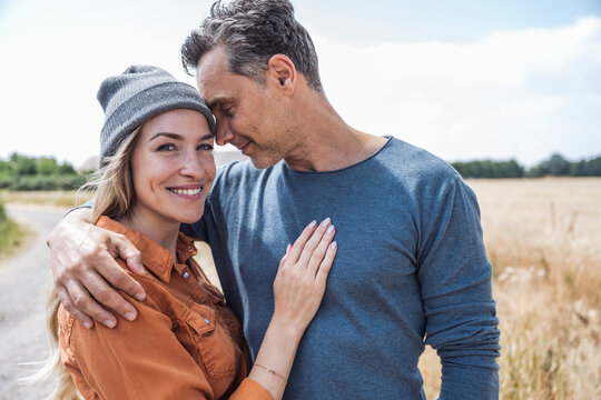 Affectionate couple spending leisure time near field