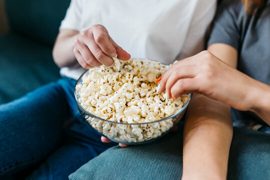 Female friends sharing popcorn at home