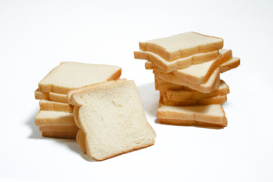 Stacks of fresh white sandwich bread slices arranged on a clean white background.