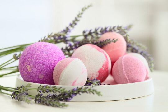 Lavender bath bombs with flowers on table in bathroom