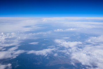 Fototapeta premium Aerial View of High-Altitude Clouds and Desert Mountains Below