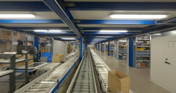 First-person point of view moving through an automated logistics warehouse with conveyor belt system and shelving units