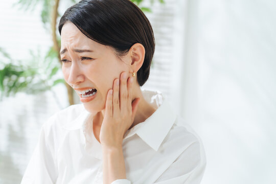 奥歯が痛むミドル女性。虫歯、親知らず、歯科、デンタルケア、悩み、知覚過敏、歯周炎、歯肉炎、顎関節症