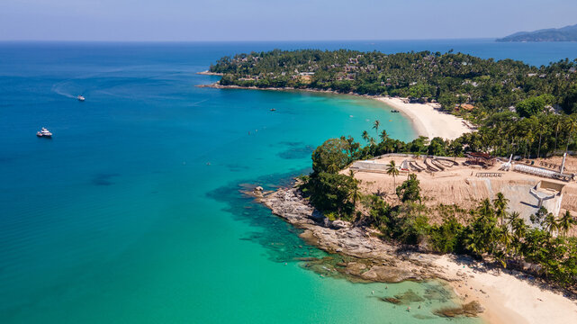 Aerial top view of Surin beach and Pansea Beach in Phuket, Thailand. Turquoise waves reach the Andaman sea coastline on a sunny day. Travel attractions for summer vacation in southeast asia.