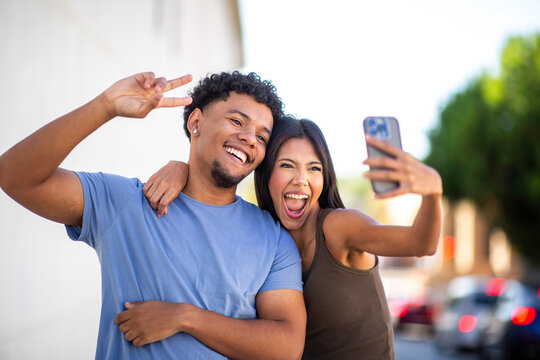 Joyful couple taking selfie outdoors in city