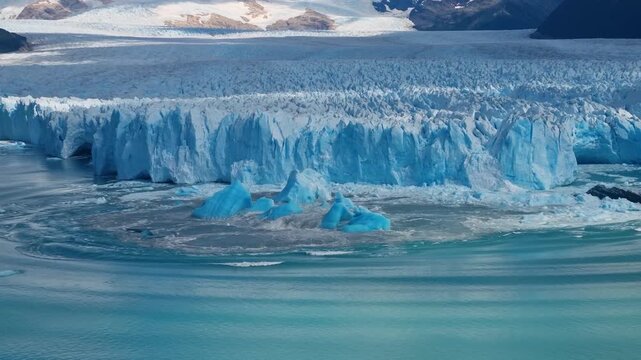 A massive ice block freshly calved from Perito Moreno Glacier floats on Lago Argentino, Argentina generating waves and showcasing the raw power of one of Patagonia&rsquo;s most spectacular natural phenomena