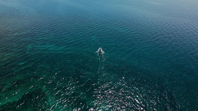 White yacht sailing through clear water of the Adriatic Sea near Pula, Croatia. High angle view.