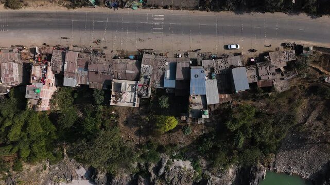 Aerial top down view of Prithvi highway and roadside houses in Nepal, sunny day