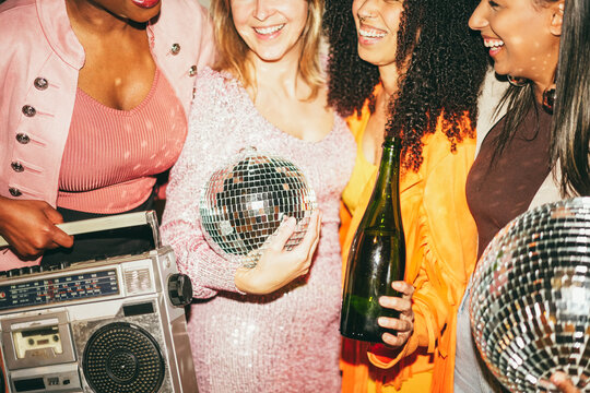 Group of multiracial girls dancing, drinking champagne and listening music outdoor - Party, summer and street nightlife concept - Main focus on right center girl face - UGC flash content