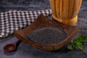 Poppy seeds in wooden bowl with mint leaf and checkered cloth © Andrei Starostin