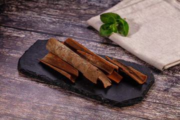 Cinnamon sticks on black slate with mint leaf © Andrei Starostin
