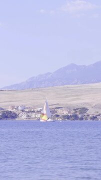 Yacht far away on sea with coast in background