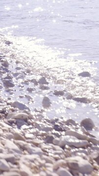 Sea waves on stone beach close up