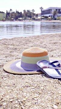 Vacation on sea beach with sandals and women hat on sand